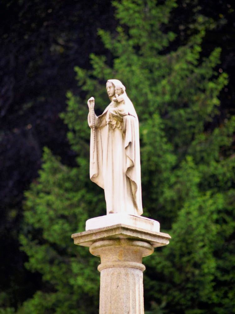 A marble statue of the Virgin Mary on a pedestal