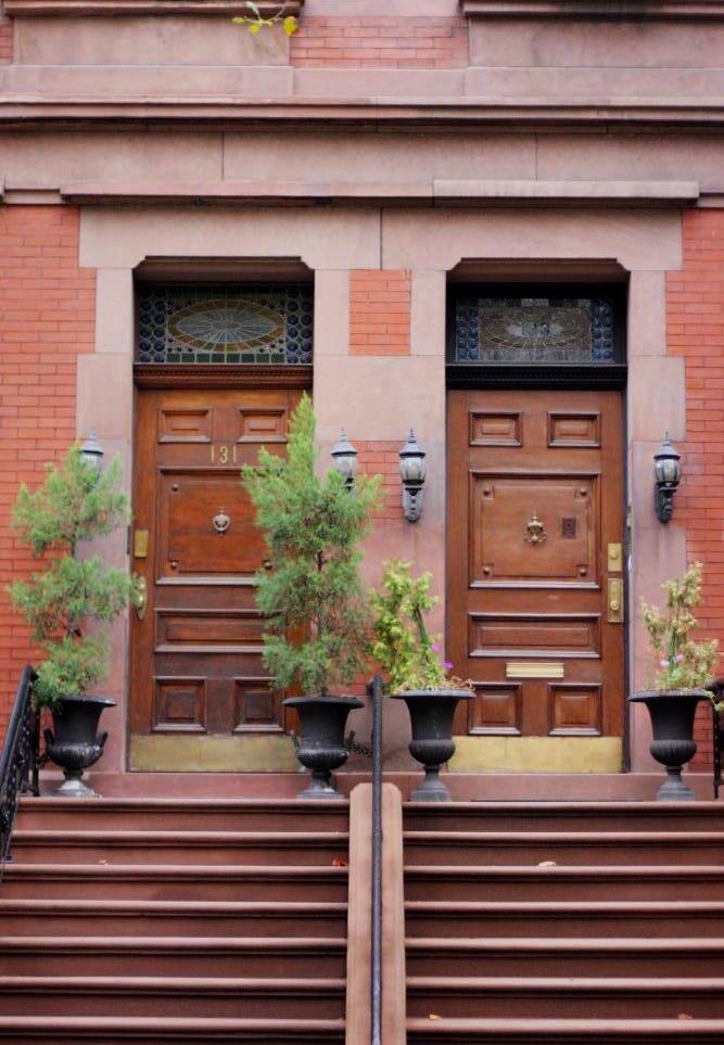 The entrances of two attached brownstone walkups